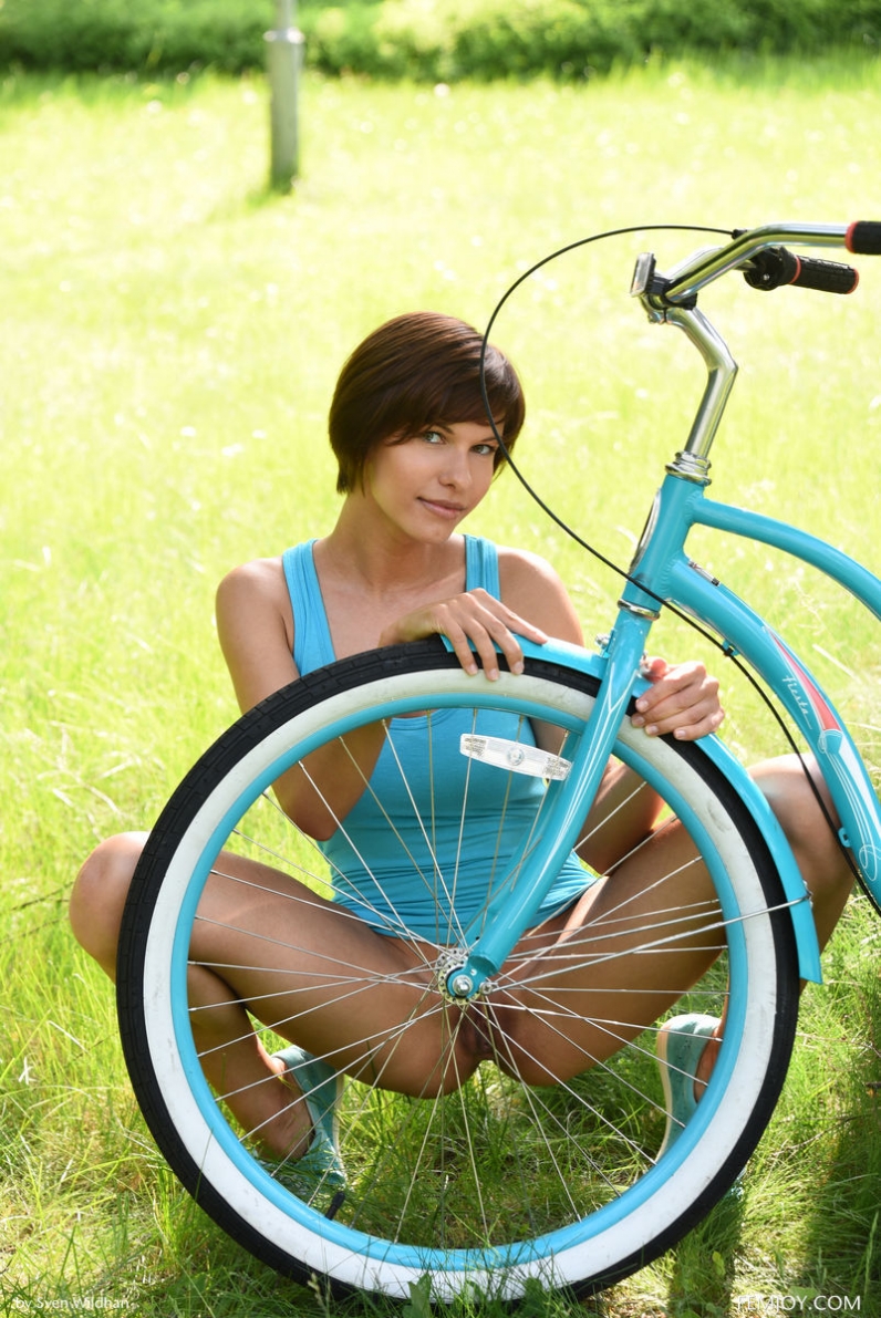 Красотка с короткой стрижкой в откровенном голубом платье слазит в велосипеда показать сладкую киску
