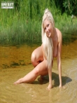 Пышная девушка с очаровательной улыбкой голышом купается в реке